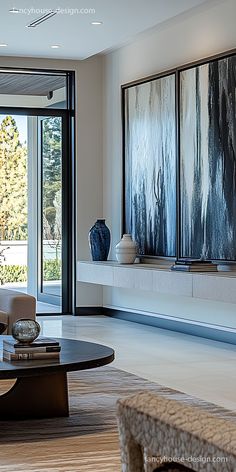 a modern living room with art on the wall and large glass doors leading to an outdoor patio