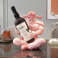 a statue of a man holding a bottle of wine on top of a glass table