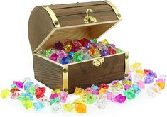 a wooden chest filled with lots of different colored rocks next to a pile of crystal cubes