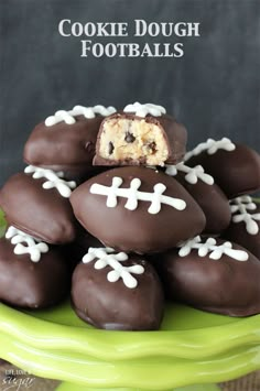 chocolate covered footballs are stacked on top of each other in a green platter