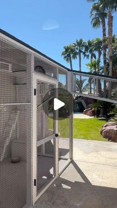 an outdoor area with a metal structure and palm trees in the background