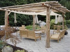 an outdoor patio with wooden furniture and umbrellas