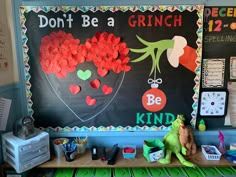 a bulletin board with the words don't be a grinch on it in front of a desk