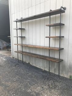 an old metal and wood shelf is leaning against the wall with two empty shelves on it