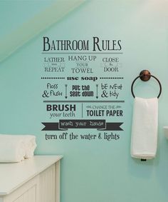 the bathroom rules wall decal is shown in black on a blue wall with white towels