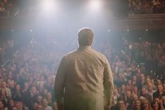 a man standing in front of an audience at a concert