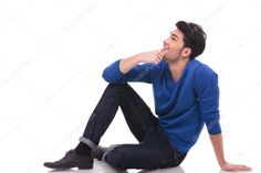 a young man sitting on the floor with his legs crossed and looking up at something