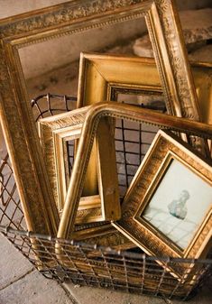 a basket filled with framed pictures sitting on top of a floor