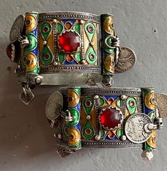 A high graded silver set of old Berber hinged enameled bracelets of Tiznit, Morocco, 1950s. I bought them in 2006 in Tiznit. Overall in good condition. The bracelets have each 4 red glass cabochons and 4 old French coins (50 centimes).On both bracelets there are engravings, see picture 3 Total weight is 225,6 grams ( 113,1 + 112,5). The width of a bracelets is 3.6 cm The inner Ø IS 5.8 CM Vintage Handmade Enamel Bangle, Handmade Vintage Enamel Bangle, Collectible Enamel Bangle Jewelry, Vintage Handmade Cuff Bracelet For Festive Occasions, Traditional Enamel Jewelry Collectible, Vintage Red Metal Bangle, Festive Silver Enamel Jewelry, Handmade Vintage Style Enamel Ring, Ornate Silver Enamel Jewelry