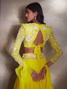 Yellow power shoulder crop featuring hand-embellished ivory camellia flowers paired with a tiered georgette lehenga and embellished waistband with ivory drops & a ruffled dupatta.From Shloka Khialani's Winter Sun collection.DELIVERY TIMEPlease allow 6-8 weeks for your outfit to arrive.FABRIC DETAILSGeorgette, NetProfessional cleaning only. Reception Gown With Ruffles In Georgette, Floor-length Ruffled Anarkali Set For Wedding, Floor-length Ruffled Georgette Choli, Elegant Georgette Anarkali Set With Ruffles, Floor-length Georgette Sets With Ruffles, Floor-length Sets With Ruffles In Georgette, Party Wear Choli With Ruffles For Reception, Party Wear Floor-length Choli With Ruffles, Ruffled Choli For Party Wear