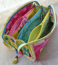 several zippered purses sitting on top of a white table next to each other