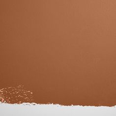 a brown wall with some white paint on it