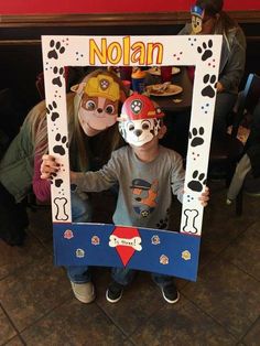 two children in costumes are posing for a photo with their dog's paw prints