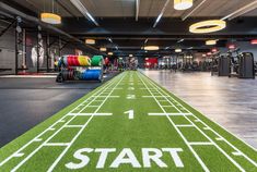 an indoor gym with artificial turf and running track