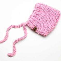 a pink crocheted bag with a brown button on the side and a string attached to it