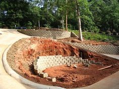 a construction site is being built on the side of a road with trees in the background