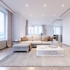 a living room with white furniture and large windows