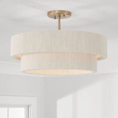 a light fixture hanging from the ceiling in a room with white walls and flooring