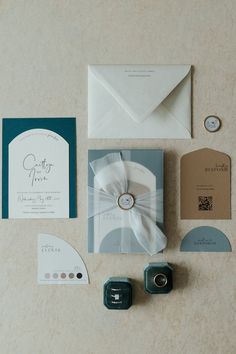 the wedding stationery is laid out on top of the table, including an envelope and ring