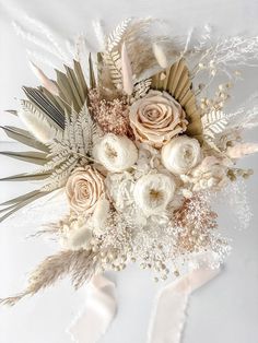 an arrangement of flowers and feathers on a white background