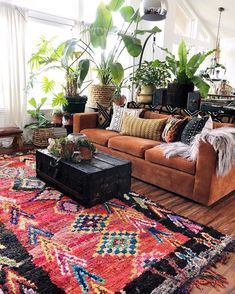 a living room filled with lots of furniture and plants on top of windowsills