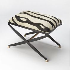 a zebra print stool with metal legs and footrests on an isolated white background