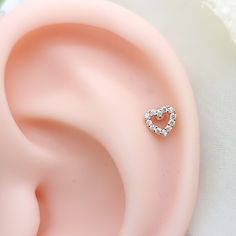 an ear with a heart shaped diamond in the middle