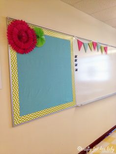 a bulletin board is hanging on the wall next to a hallway with flags and bunting