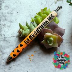 a pen that is sitting next to some succulents