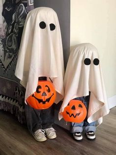 two children in halloween costumes standing next to each other