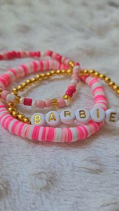 Cute barbie themed bracelet set of 3!One pink, random pattern clay bead bracelet paired with a cute gold barbie bracelet, and a pink and gold bracelet! Both very stretchy and easy to put on! 3 different sizes available! Beaded Bracelets Barbie, Barbie Themed Bracelet, Popular Clay Bead Bracelets, Clay Bracelet Designs, Barbie Clay Bead Bracelet, Cool Clay Bead Bracelet Ideas, Barbie Beaded Bracelet, Pink Bead Bracelet Ideas, Clay Bead Bracelet Diy