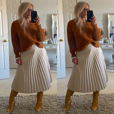 a woman taking a selfie while wearing a pleated skirt and knee high boots