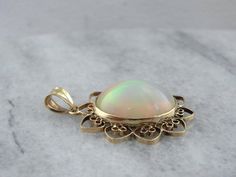 This Mid Century, simple pendant is a great frame for the outstanding Ethiopian Opal gem that we've set at the center. This is a wonderful stone, filled not only with greens and oranges, but also with a rare, pink glow at the center! The radiant style of the frame certainly brings out the glow of the opal! This pendant does not come with the chain shown. Please feel free to contact us, we will help you find the perfect chain for your style and budget! Metal: 14K Yellow Gold Gem: Ethiopian Opal 8 Simple Pendant, The Glow, Opal Pendants, Oval Cabochon, Eternity Bands, Ethiopian Opal, Jewelry Necklace Pendant, Gemstone Rings, Opal