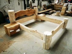 a wooden bed frame sitting on top of a floor next to other woodworking tools