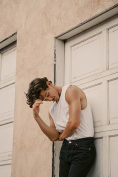 a young man leaning against a garage door