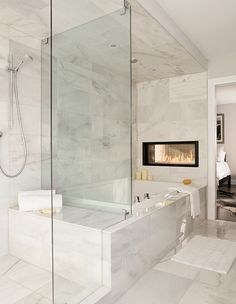 a bathroom with a fireplace in the wall and white tile flooring on the walls