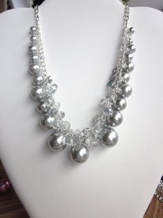 "This stunning silver gray pearl and crystal glass pearl necklace will add the finishing touch to any outfit, so elegant.  This is a very gorgeous necklace set.    This necklace is adjustable in length from 15\" up to 20\".  Pearls are in various sizes from 6mm to 20mm.   Crystals are in various shapes and sizes, clear and AB; Swarovski and Austrian crystals.  Each pearl and crystal was hand wired to the adjustable length silver plated double curb chain.  This is finished with a lobster claw closure.    Shipping to the US is flat rate Priority Mail Small Box, unless another method is requested. International Shipping will be for actual shipping charges. Please email for charges and shipping options before you check-out.  Price shown below is for international priority mail flat rate small Silver Crystal Pearl Necklace For Party, Gray Pearl Jewelry For Party, Silver Pearl Bridal Necklace For Party, Silver Bridal Necklace With Pearl Chain And Crystal, Silver Beaded Crystal Pearl Necklace, Silver Crystal Beaded Pearl Necklace, Silver Crystal Necklace For Mother Of The Bride, Silver Crystal Bridal Necklace With Round Beads, Silver Pearl Drop Necklace For Mother Of The Bride