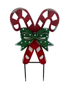 a red and green christmas decoration on top of a metal stand with candy canes