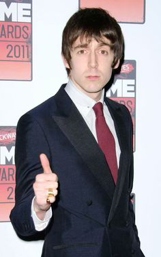 a man in a suit and tie giving the thumbs up sign at an awards event