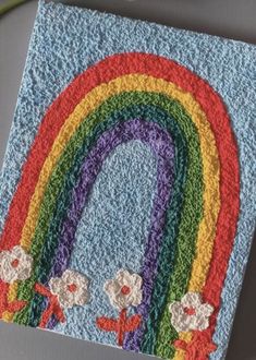 there is a crocheted rainbow with flowers on it