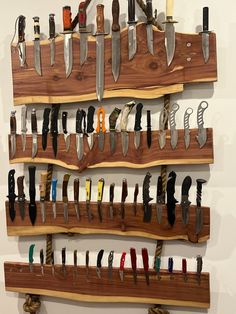 a wall mounted knife rack with knives on it's sides and several different types of knives hanging from them