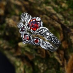 Crafted from sterling silver, this set features a nature-inspired design that encapsulates the spirit of the forest. The dainty silver leaves and unique garnet stones make this set a perfect choice for a woman who appreciates the delicate beauty of the natural world.  Characteristics: Metal - Recycled solid sterling silver  Stone - Cubic Zirconia Finish - Oxidized. View all silver nature wedding ring sets: https://www.etsy.com/shop/TinyShinyJewel?ref=seller-platform-mcnav&section_id=45348609 Care instructions: To care for the ring, avoid contact with water and chemicals such as perfumes and lotions. When the ring is not in use, store it in a dry, cool place to prevent tarnishing. Additional information:  ✦ All rings are made to order. An average turnaround time is 1-5 days. I will make eve Silver Magical Promise Jewelry, Silver Ethereal Jewelry With Birthstone, Fantasy Sterling Silver Jewelry For Anniversary, Silver Nature-inspired Wedding Jewelry, Nature-inspired Silver Wedding Jewelry, Magical Sterling Silver Wedding Jewelry, Ethereal Sterling Silver Wedding Jewelry, Elegant Silver Jewelry For Fantasy Events, Fantasy Silver Rings For Anniversary