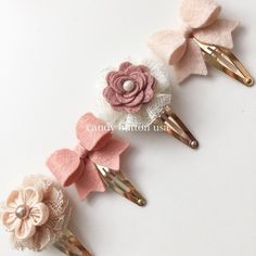 three hair clips with flowers on them sitting next to each other