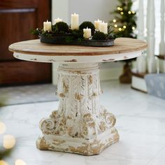 a table with candles on it in front of a christmas tree