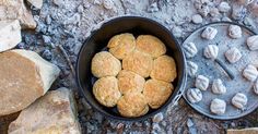 a pan filled with food sitting on top of a stone ground next to some rocks