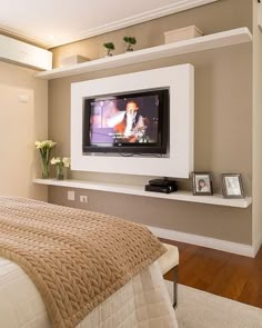 an image of a bedroom with a tv on the wall and other things in the room