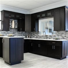 a kitchen with black cabinets and white counter tops