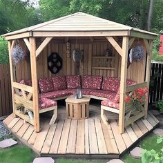 a wooden gazebo sitting on top of a lush green field