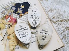 three spoons that are sitting on top of an open book with words written on them