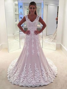 a woman standing in front of a mirror wearing a wedding dress